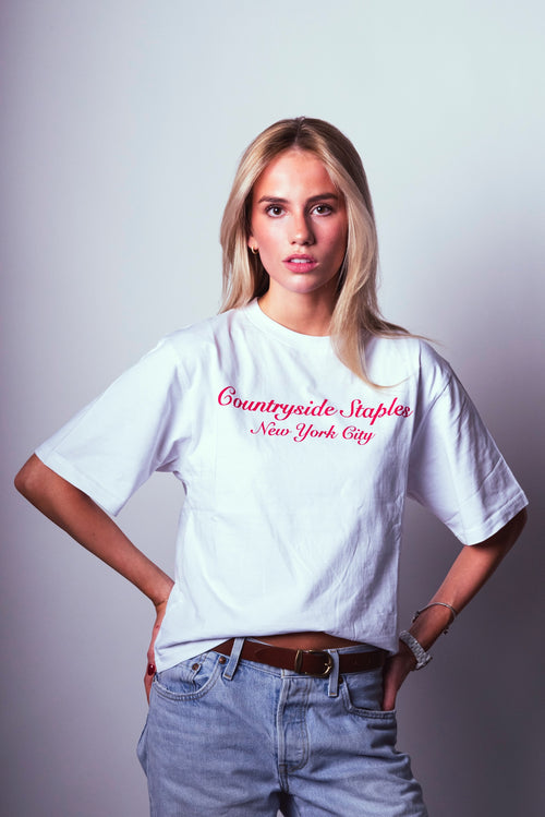 Model wearing Countryside Staples New York City t-shirt with logo across chest.