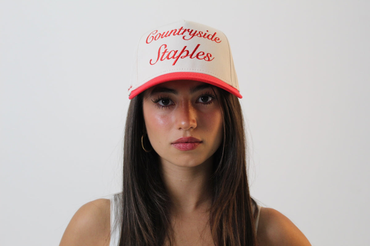 Model wearing Friends and Family Countryside Staples Hat, front view with embroidered logo.