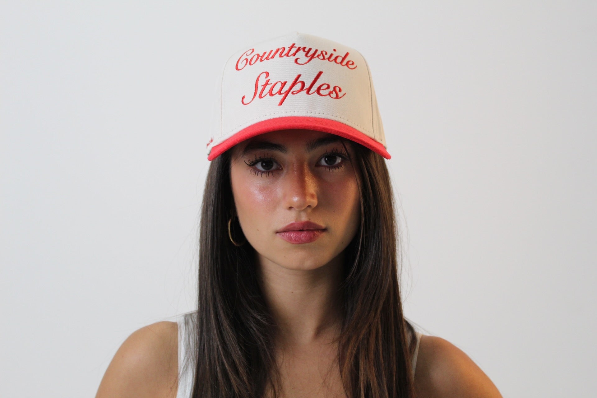 Model wearing Friends and Family Countryside Staples Hat, front view with embroidered logo.