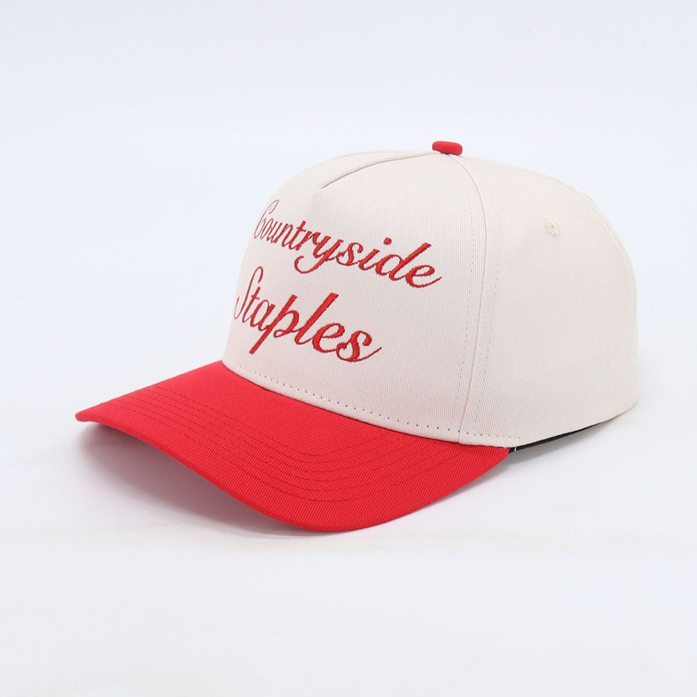 Side View of Friends and Family Countryside Staples Hat laid flat on a white background.