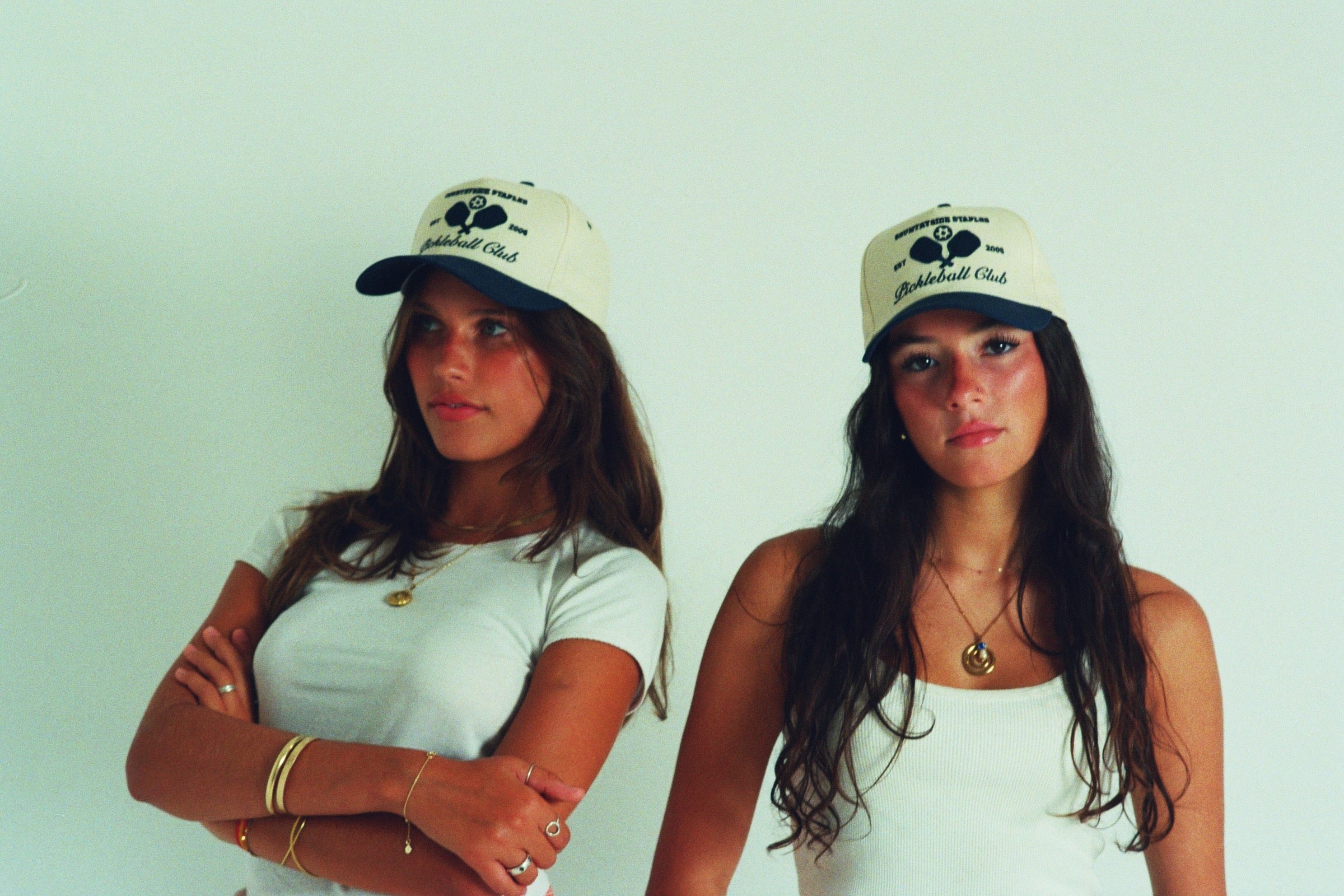 Sisters modeling Countryside Staples Pickleball Club hat in film.