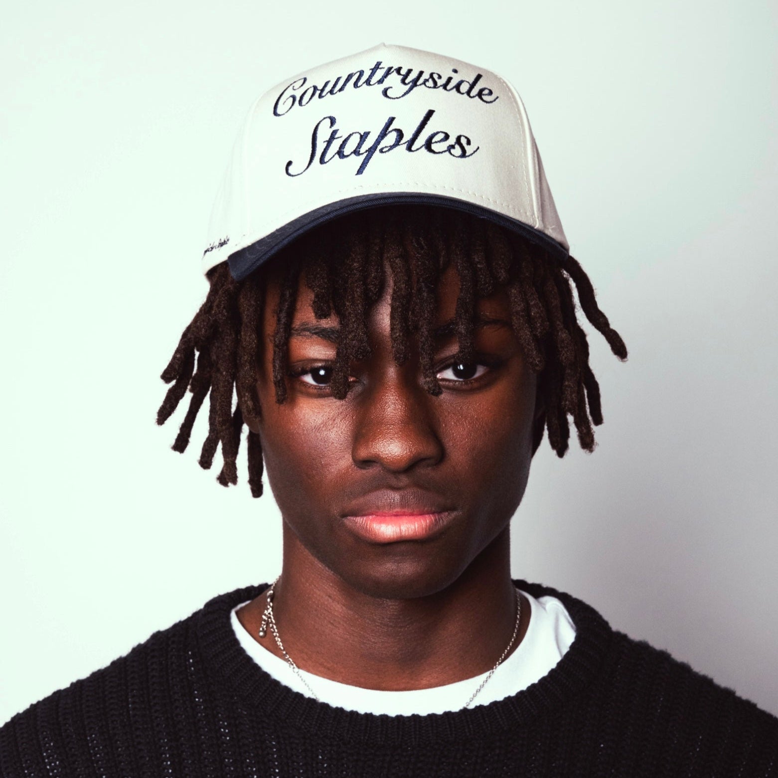 Model wearing Signature Navy & Cream Countryside Staples Hat front view with embroidered logo