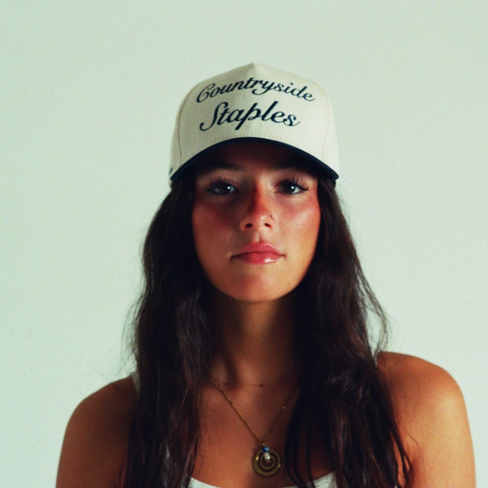 Woman model wearing Signature Navy & Cream Countryside Staples Hat with embroidered logo in film.