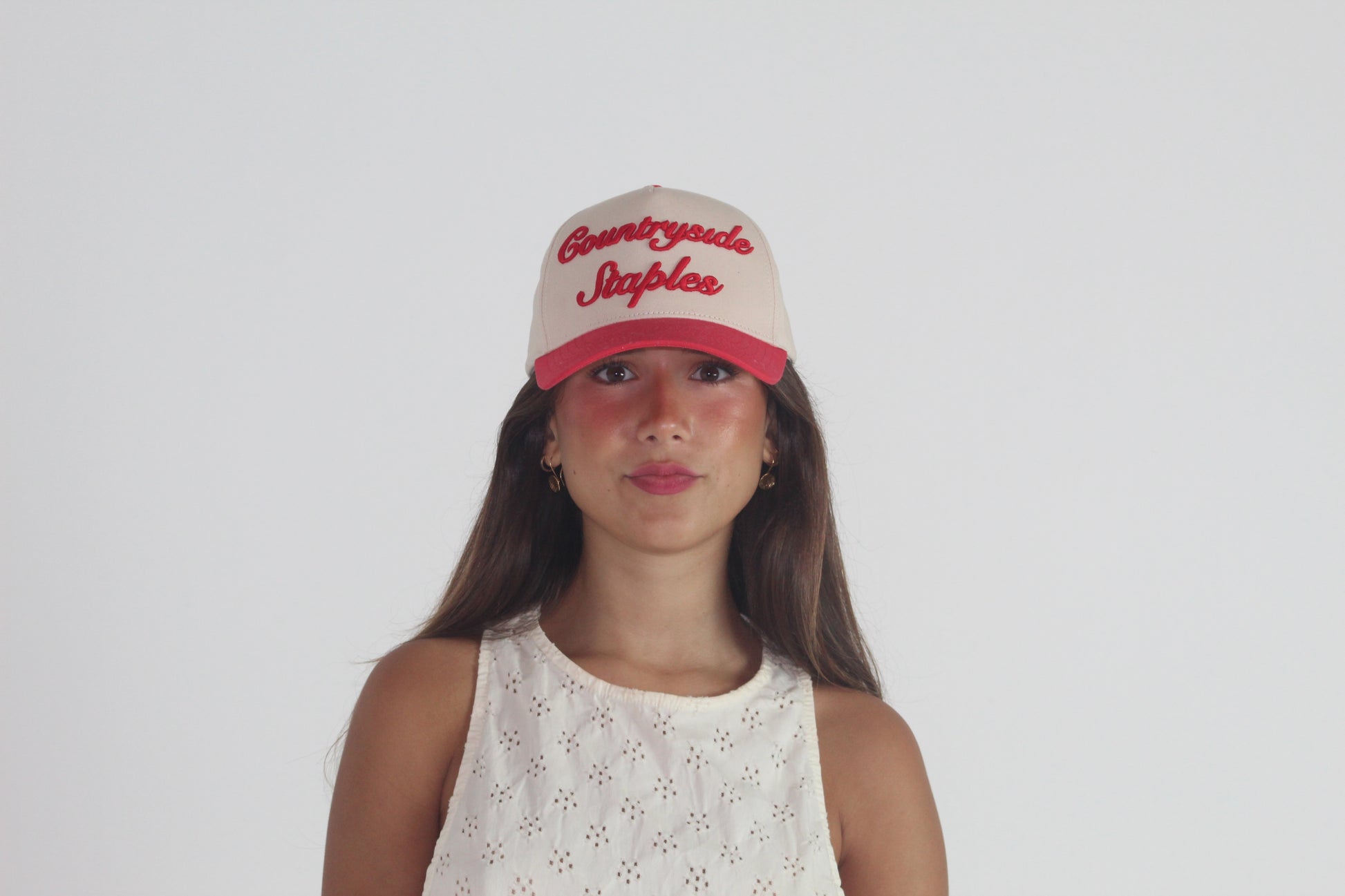 Model styling Signature Red & Cream Countryside Staples Hat front view with 3D embroidered logo