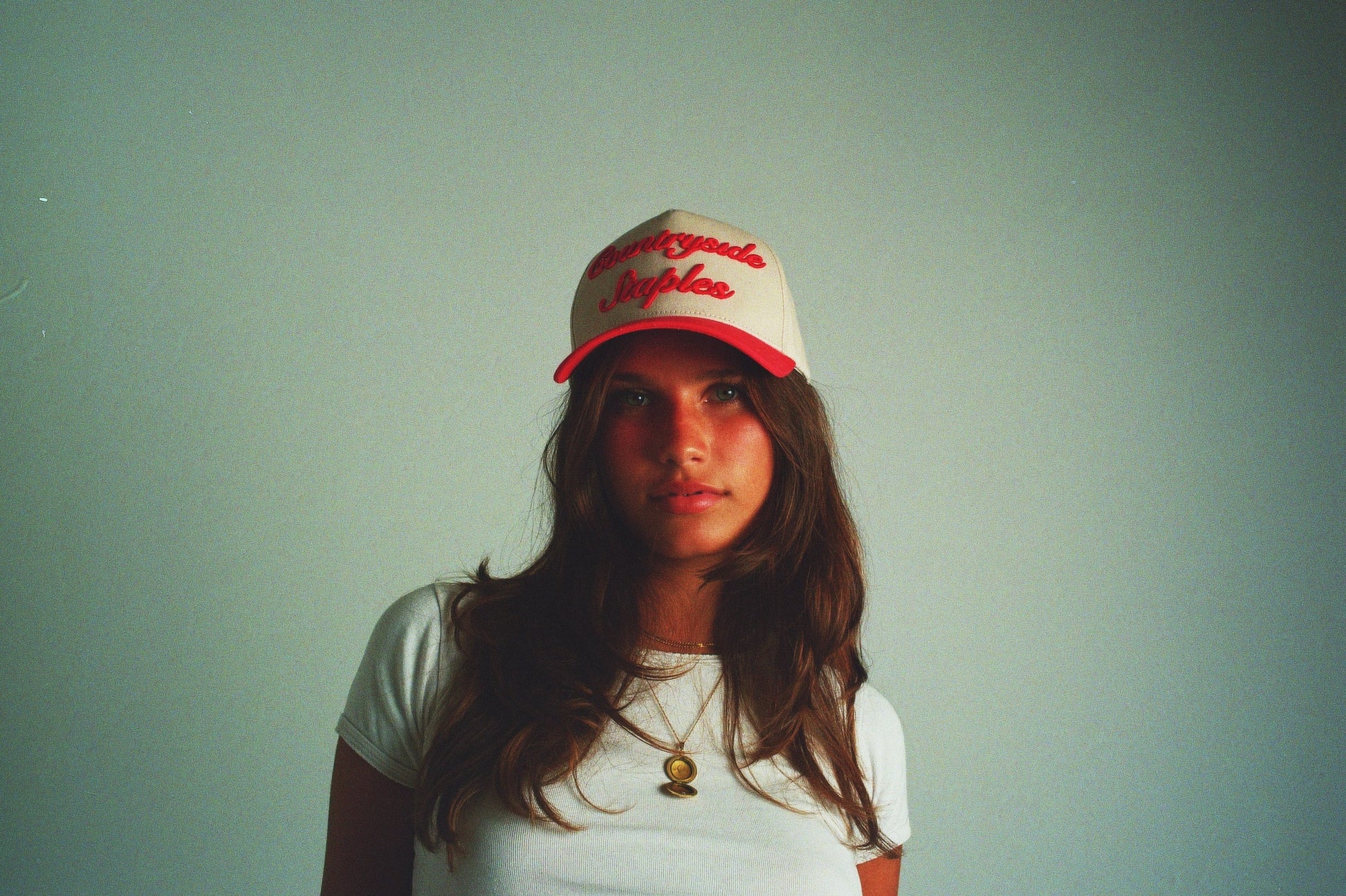 Model wearing Red & Cream Countryside Staples Hat with 3D embroidered logo in film.
